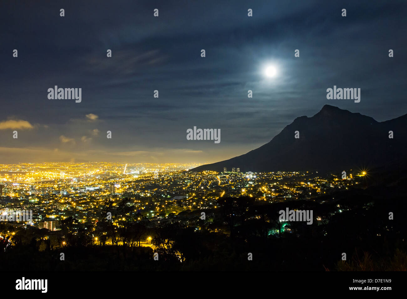 Luci di Città del Capo e la luna piena sopra Devils Peak, Table Mountain di notte Foto Stock