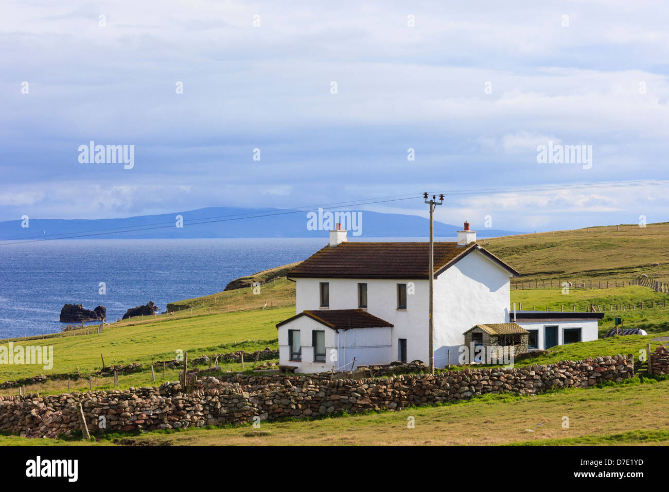 Remote casa dipinta di bianco che si affaccia Braewick Bay sulla costa scozzese a Eshaness, isole Shetland, Scotland, Regno Unito Foto Stock