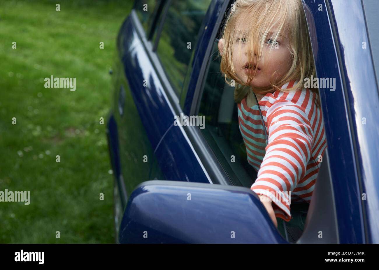 Bimba bionda bambino che gioca all'interno di un automobile Foto Stock