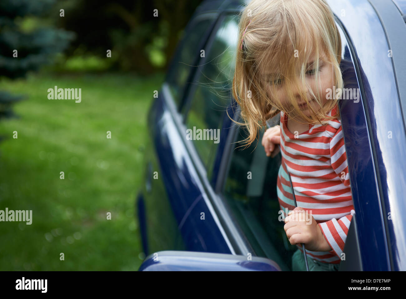Bimba bionda bambino che gioca all'interno di un automobile Foto Stock