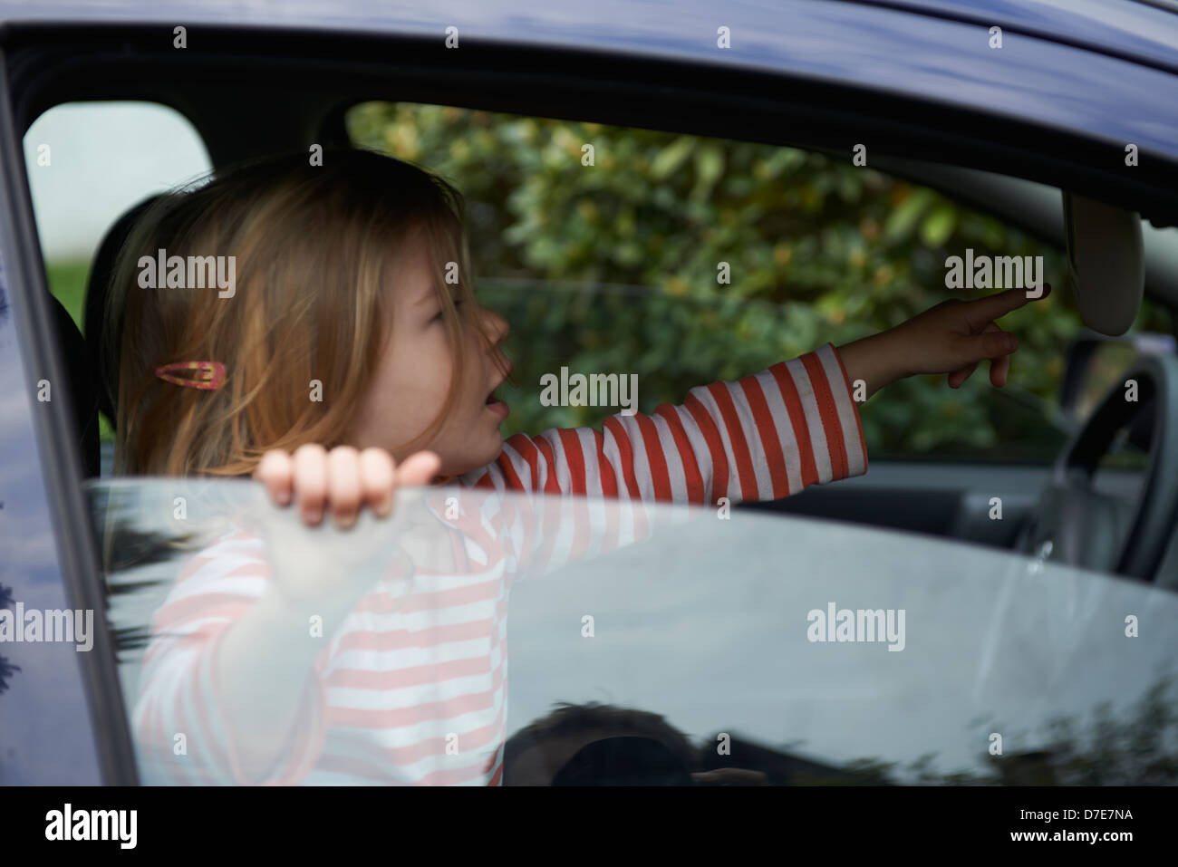Bimba bionda bambino che gioca all'interno di un automobile Foto Stock