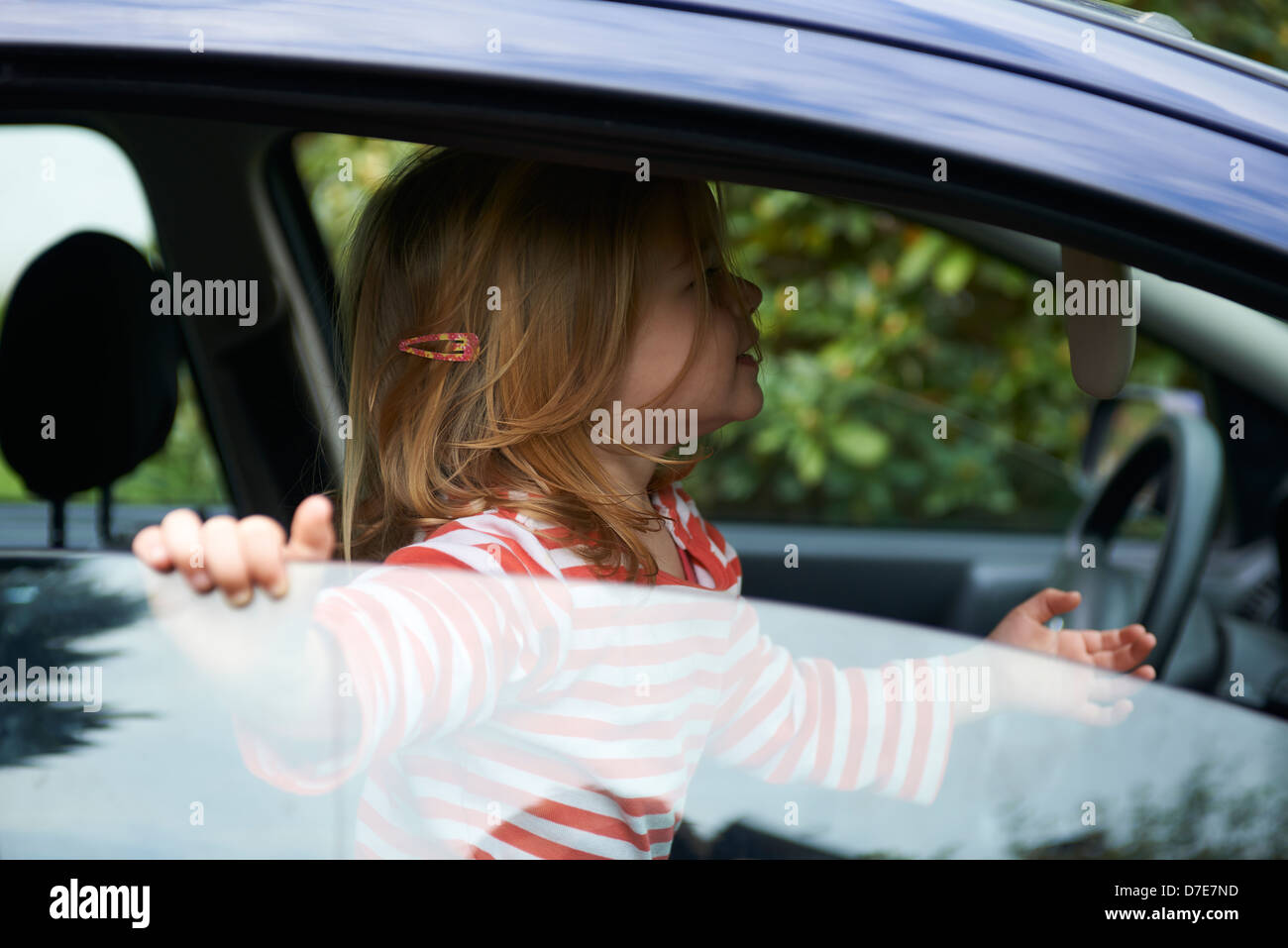 Bimba bionda bambino che gioca all'interno di un automobile Foto Stock