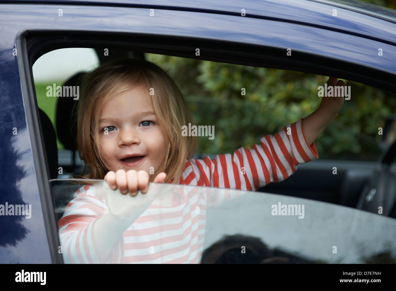 Bimba bionda bambino che gioca all'interno di un automobile Foto Stock