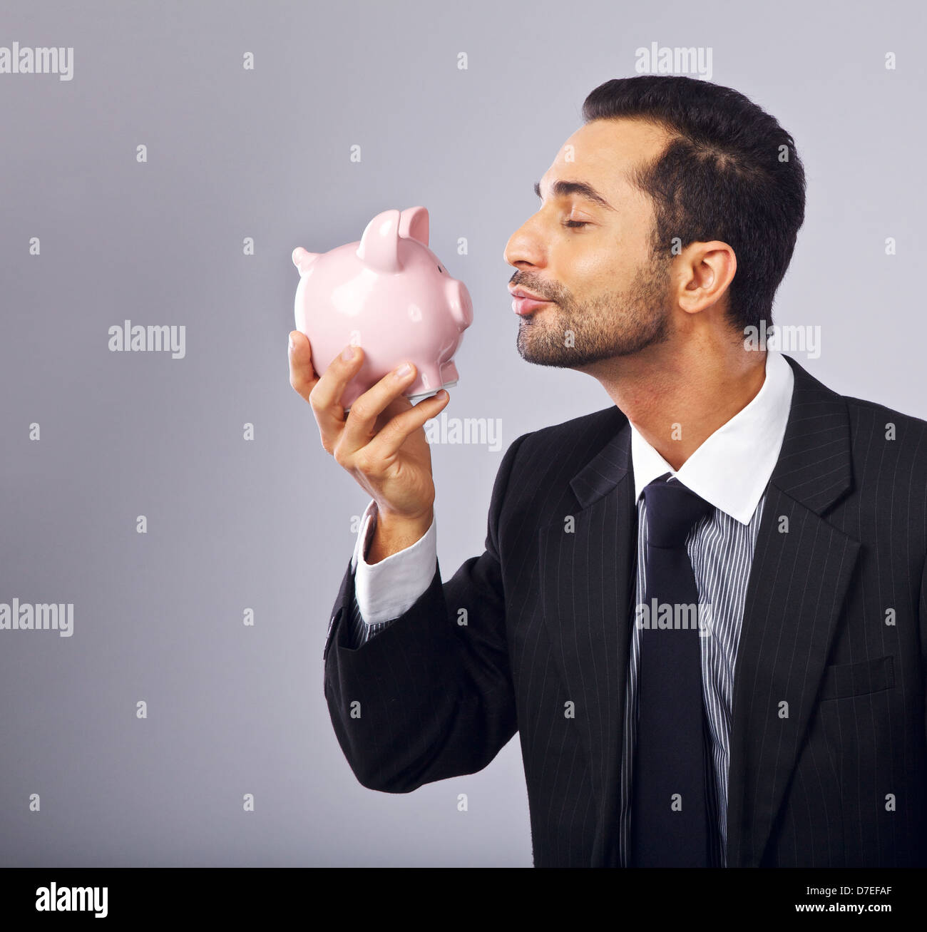 Ritratto di un esecutivo bello baciare una banca di monete Foto Stock