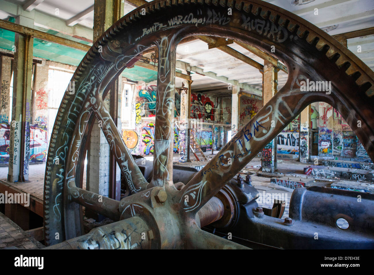 Il patrimonio industriale all'interno dell'ex fabbrica del ghiaccio di Berlino con un grande ingranaggio e un sacco di graffiti , Germania Foto Stock