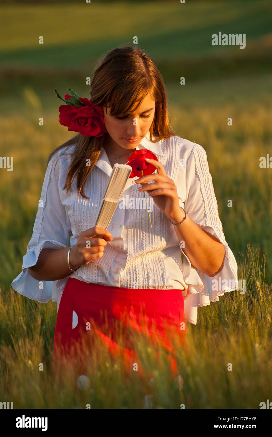 Campo di papaveri selvatici con la ragazza spagnola in abito tradizionale fiori di primavera il papavero Fiesta Ferria, fiori selvatici Andalusia Spagna Foto Stock