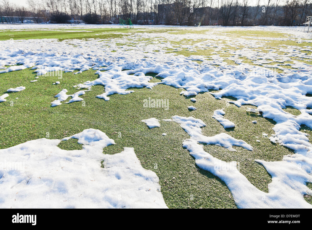 Snowy outdoor campo di calcio nella primavera bassa stagione Foto Stock