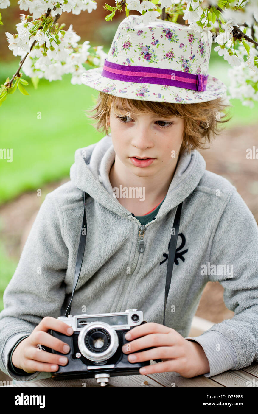 Ritratto di un ragazzo giocando all'aperto con una vecchia macchina fotografica. Foto Stock