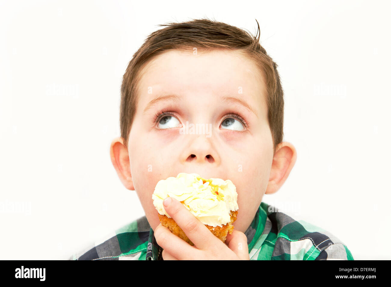 Bello piccolo ragazzo di mangiare un fresco bicchiere di crema torta con faccia sporchi Foto Stock