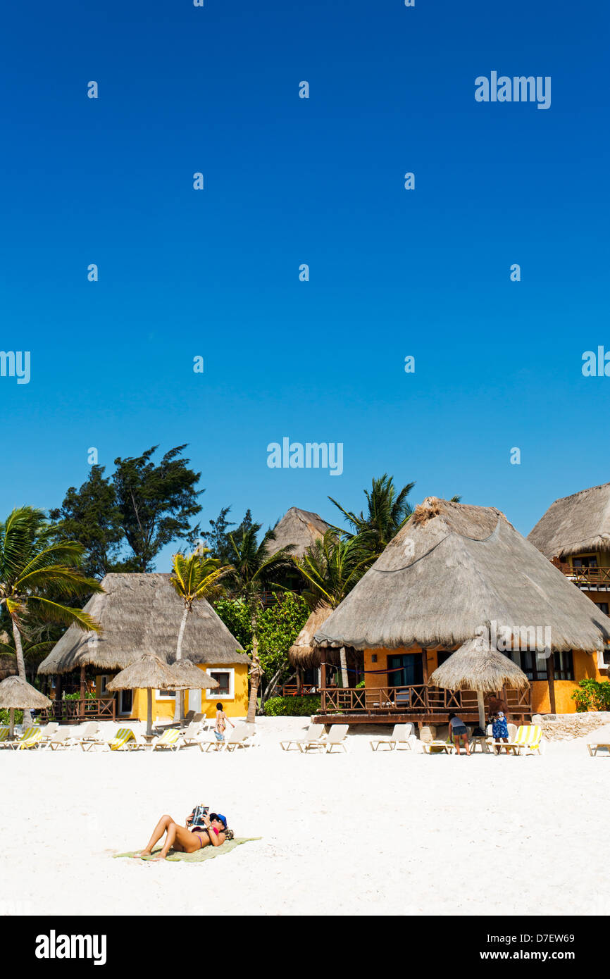 Stile cabana alloggio sulla spiaggia con la sola donna abbronzatura e la lettura Foto Stock
