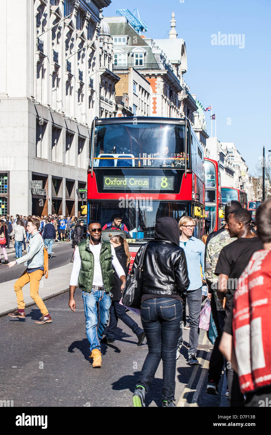 Pedoni che attraversano Oxford Street di fronte a un autobus a due piani, Londra, Inghilterra, Regno Unito. Foto Stock