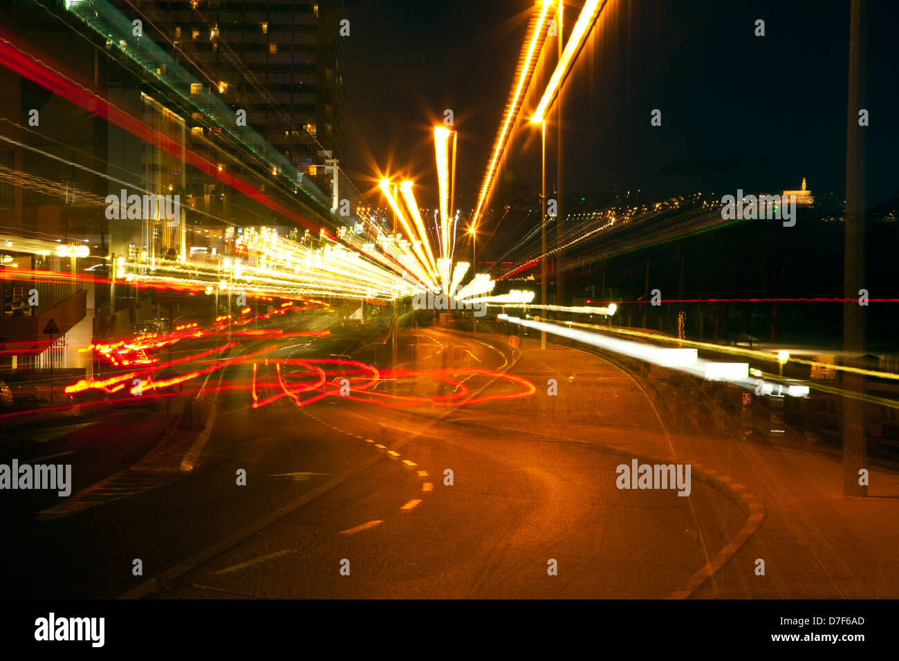 Una vista Tel-Aviv boardwalk in serata città vecchia Jaffa visto in background. la lente della fotocamera è stata zoom indietro durante l'esposizione così Foto Stock