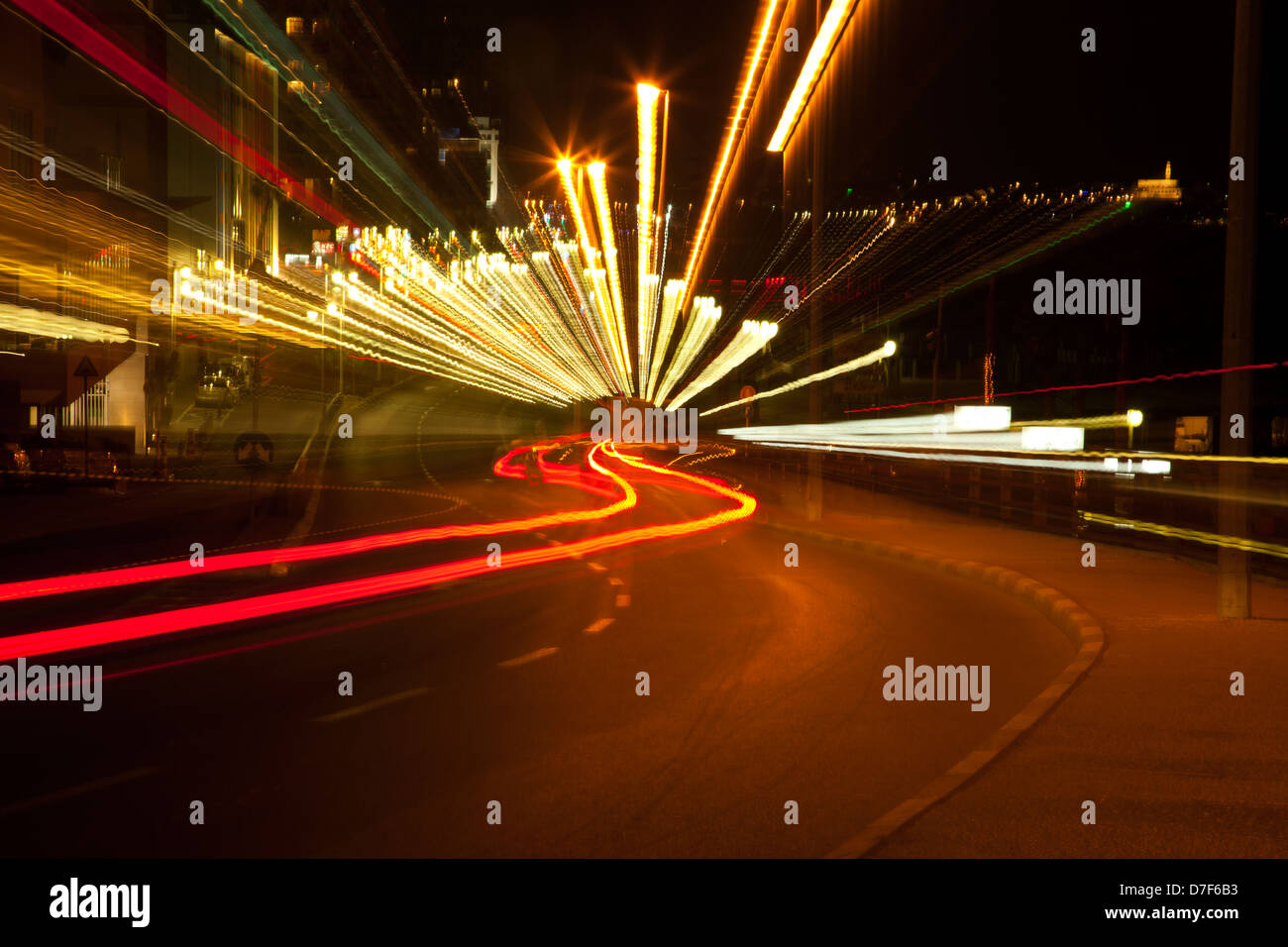 Una vista Tel-Aviv boardwalk in serata città vecchia Jaffa visto in background. la lente della fotocamera è stata zoom indietro durante l'esposizione così Foto Stock