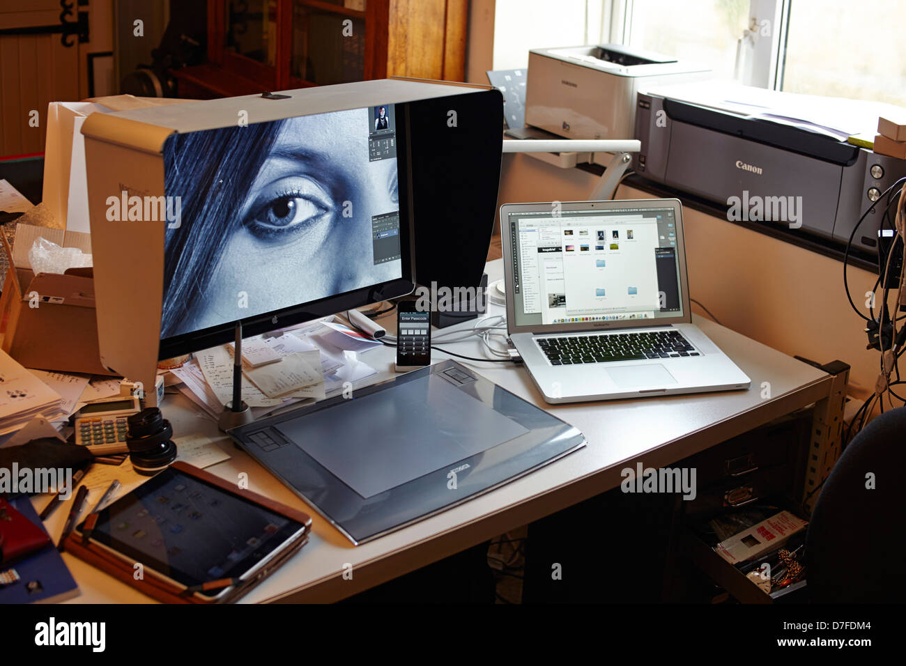 Workstation per fotografi con MacBook Pro, grande schermo, iPad e stampanti Foto Stock