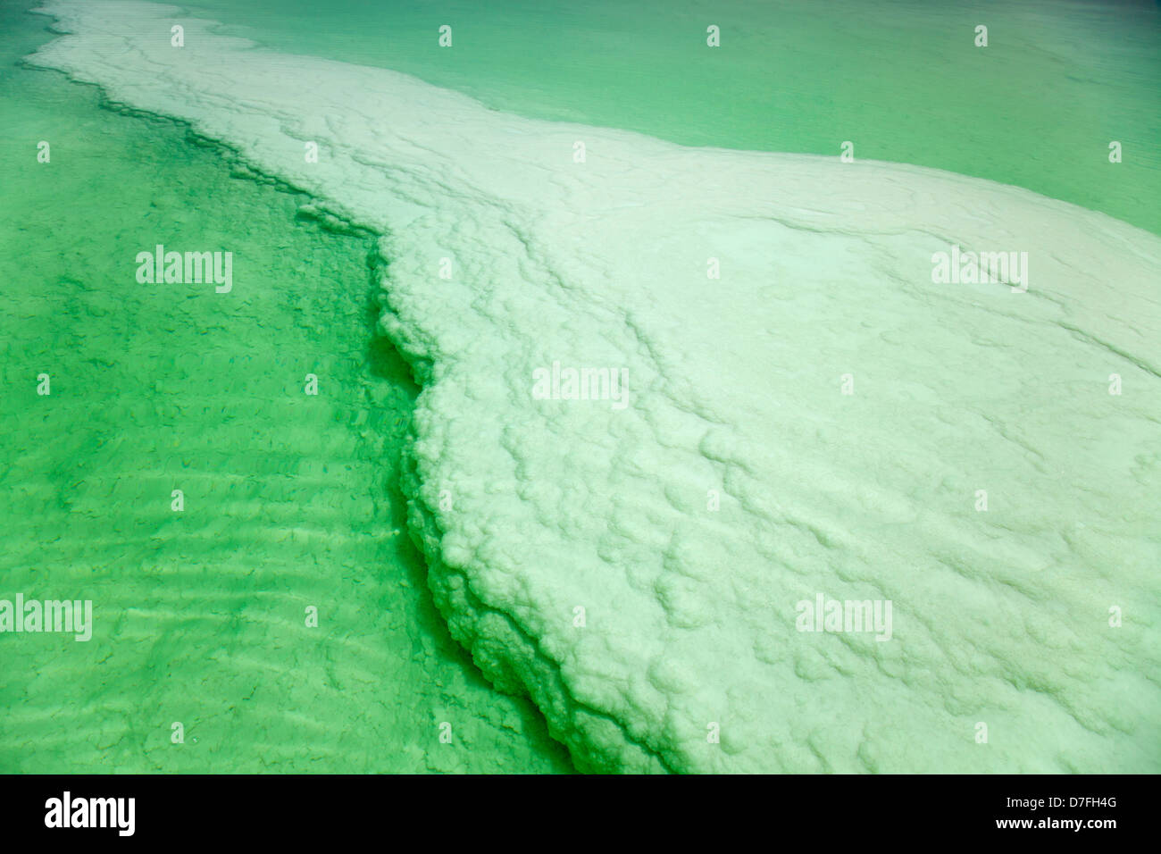 Uno sguardo attraverso il verde chiaro acqua famosa in tutto il mondo il Mar Morto che sotto la sua superficie grandi sale coperte rock può essere visto Foto Stock