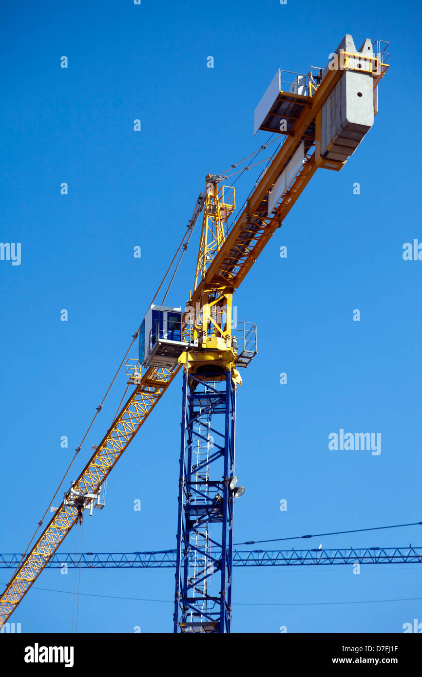 Basso angolo di vista laterale posteriore della costruzione di gru a torre del lato posteriore la visualizzazione di calcestruzzo pesante dei pesi che sono mantenendolo equilibrato. Foto Stock