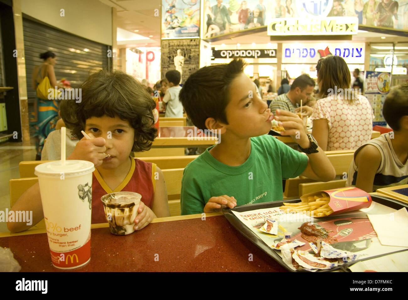 I bambini di mangiare fast food al McDonald's Foto Stock