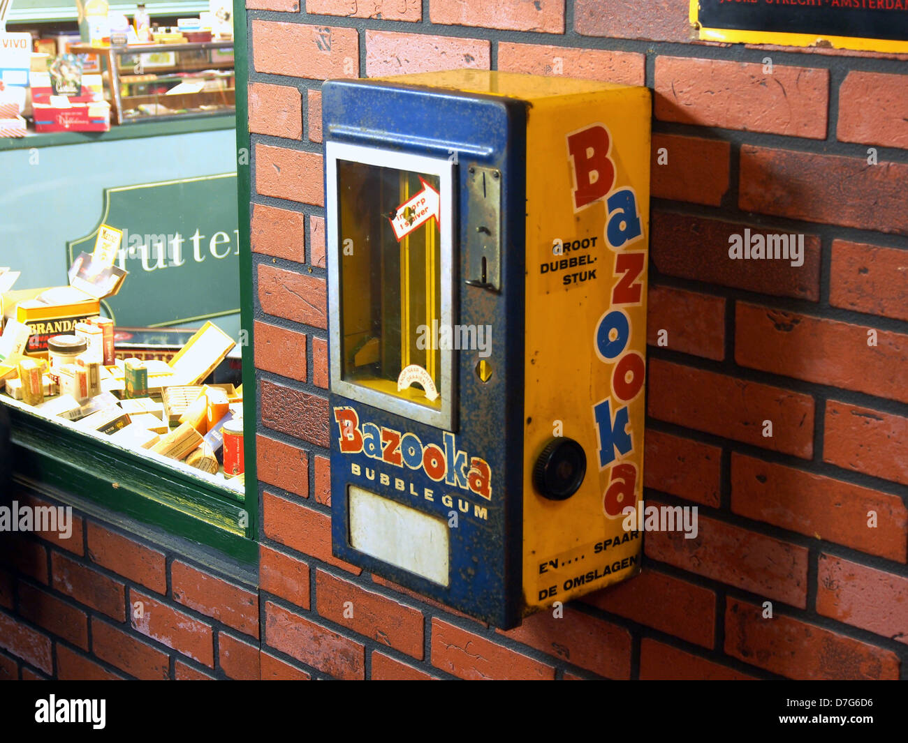 Il distributore automatico Bazooka è un pezzo vintage di cultura pop, caratterizzato da una macchina che eroga gomma da bolle Bazooka. Questo manufatto nostalgico mette in risalto il design e il consumismo della metà del XX secolo. Foto Stock