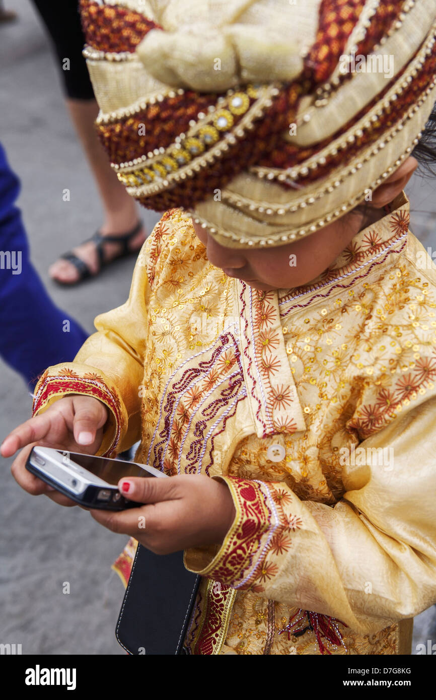 Ritratto di un giovane ragazzo utilizzando un telefono cellulare in Trafalgar Square, London, Regno Unito Foto Stock