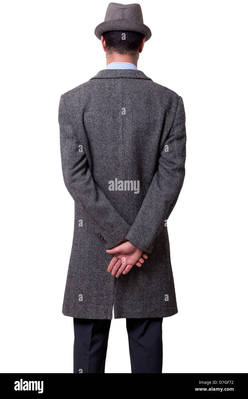 Una persona vestita in cappotto grigio grey hat in piedi il suo ritorno alla telecamera tenendo la sua mano destra sulla sua sinistra. Isolato su Foto Stock