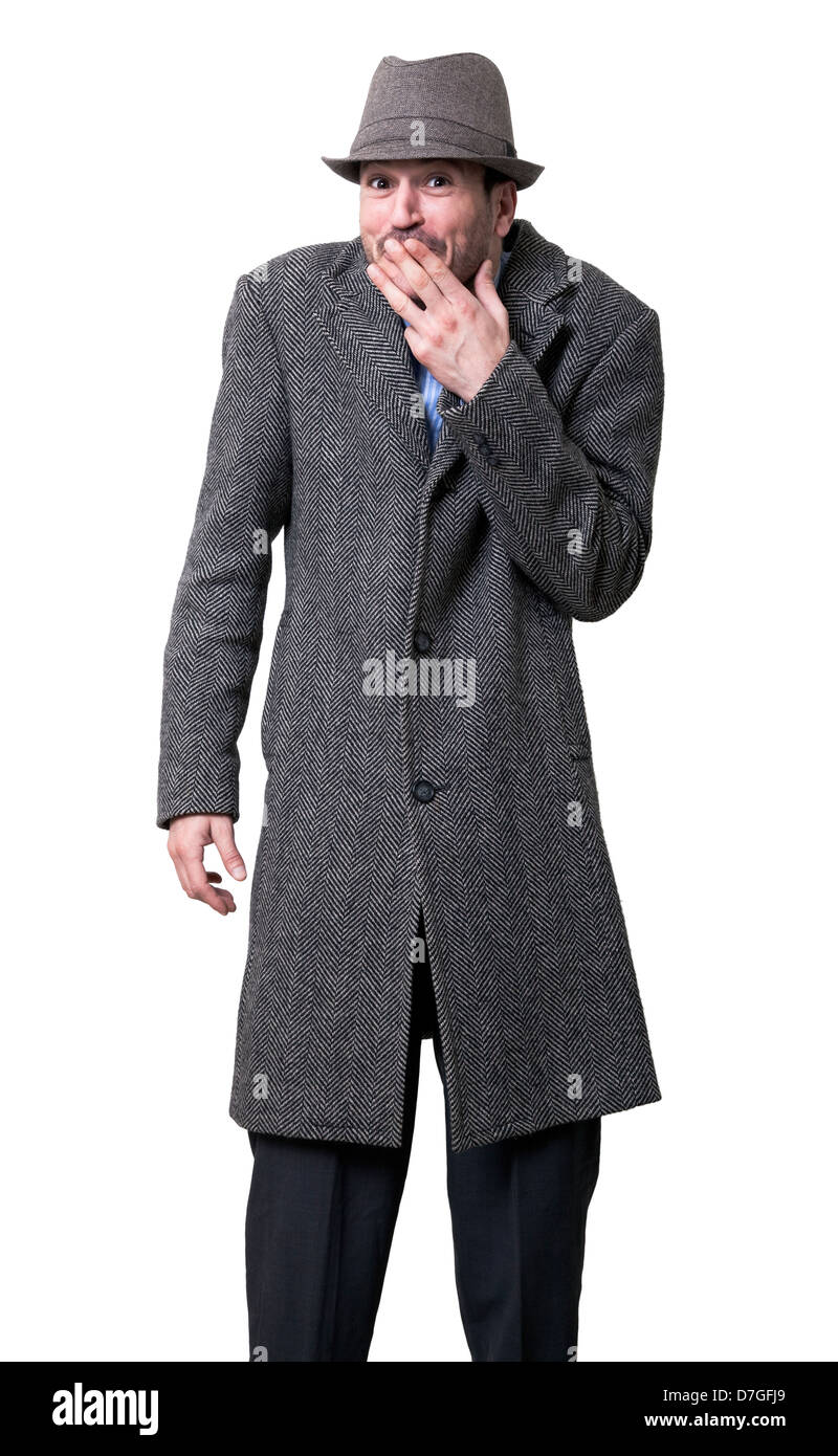 Un giovane adulto maschio grigio indossa soprabito matching hat in piedi che guarda alla telecamera un divertito di espressione sul suo volto la sua mano sinistra Foto Stock