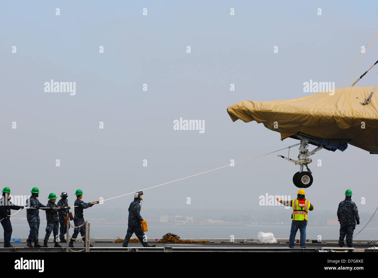 US Navy marinai spostare un X-47B Unmanned Combat Air System aeromobile a bordo della portaerei USS George H.W. Bush Maggio 6, 2013 in Norfolk, VA. La USS George H.W. Bush è programmato per essere la prima portaerei a catapultare il lancio di un velivolo senza equipaggio dal suo ponte di volo. Foto Stock