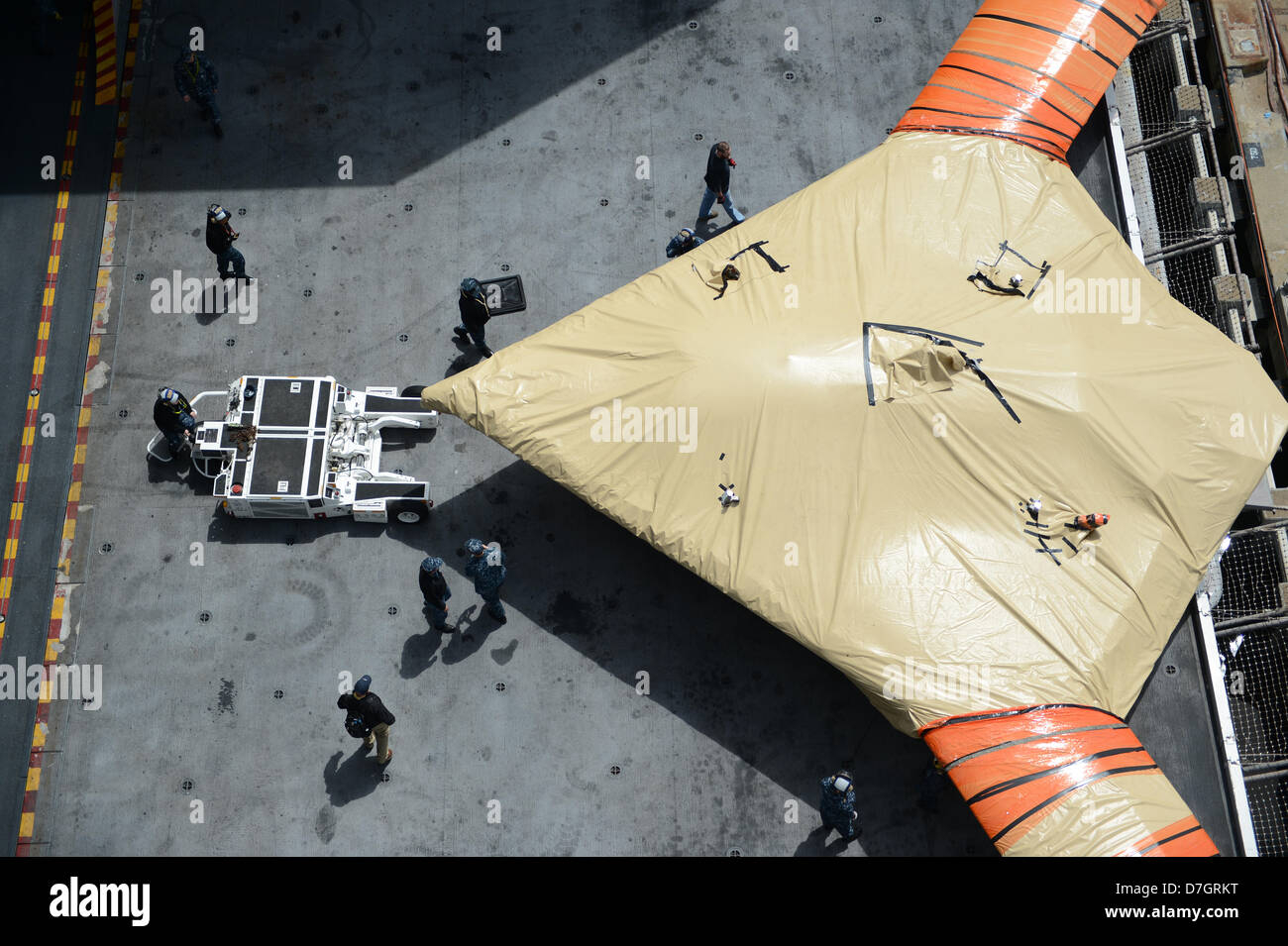 US Navy marinai spostare un X-47B Unmanned Combat Air System aeromobile a bordo della portaerei USS George H.W. Bush Maggio 6, 2013 in Norfolk, VA. La USS George H.W. Bush è programmato per essere la prima portaerei a catapultare il lancio di un velivolo senza equipaggio dal suo ponte di volo. Foto Stock