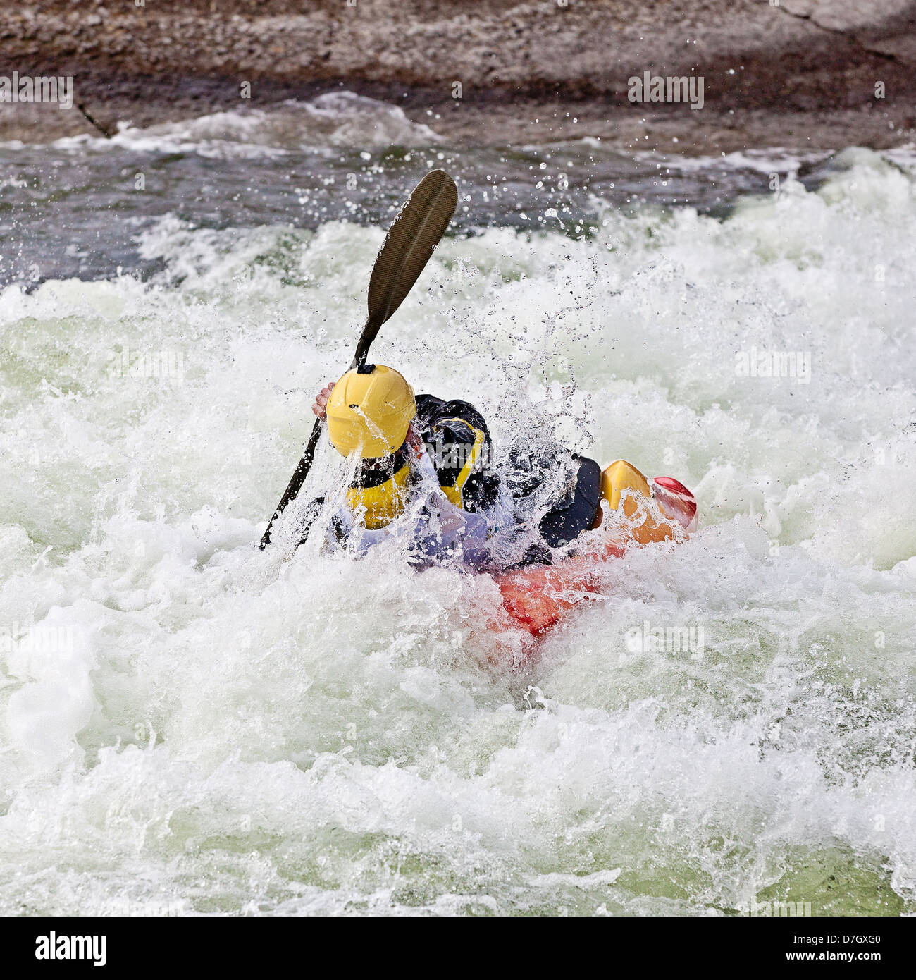 Un maschio attivo kayaker di laminazione e di navigare in acque agitate Foto Stock