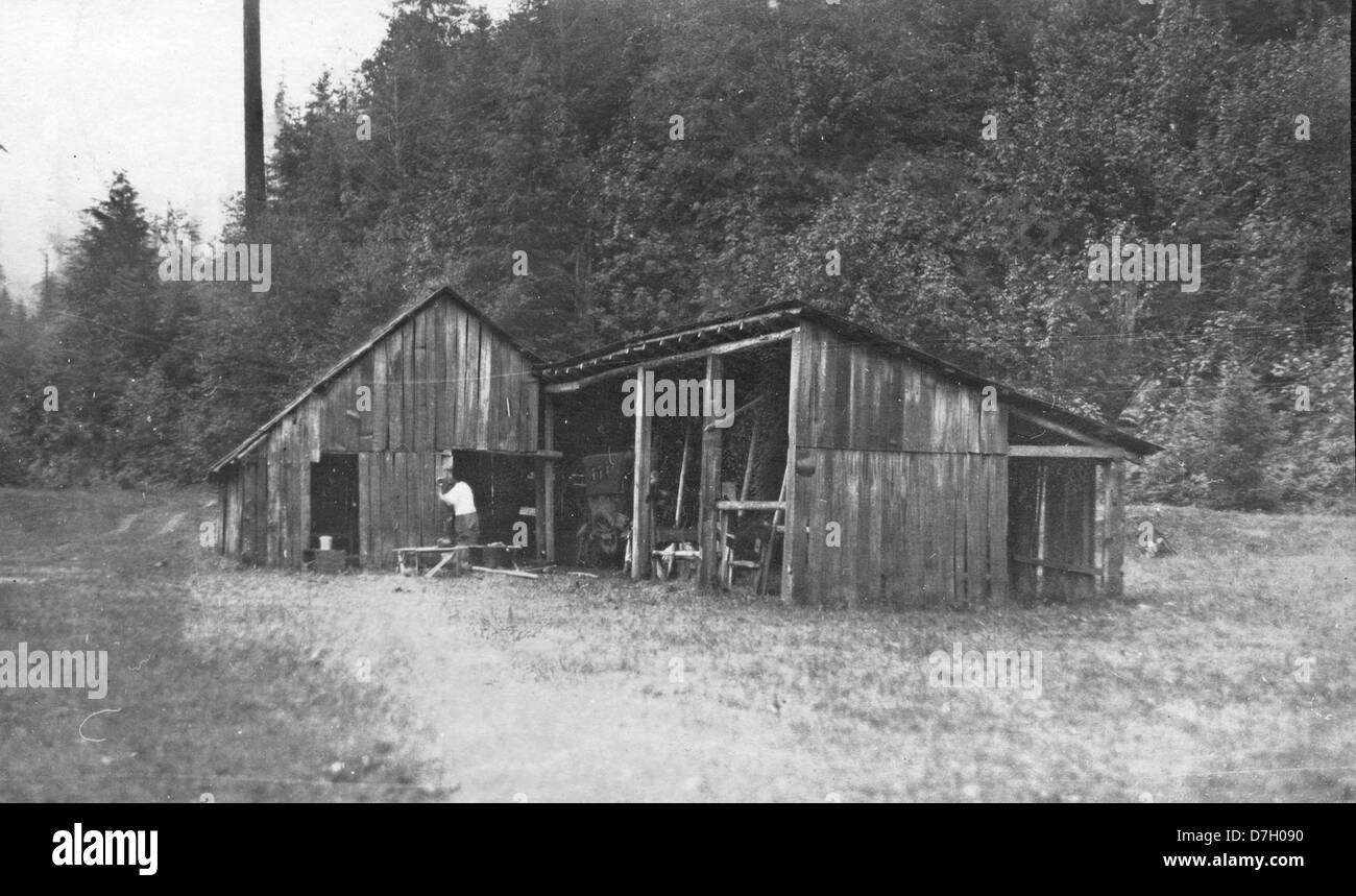 Questa foto storica del fienile della "Half-Way House" a Santiam Pass, Oregon, cattura il fascino rustico dell'architettura occidentale dei primi anni del XX secolo. La fotografia fa parte della collezione Gerald W. Williams e mostra il paesaggio rurale dell'Oregon. Foto Stock