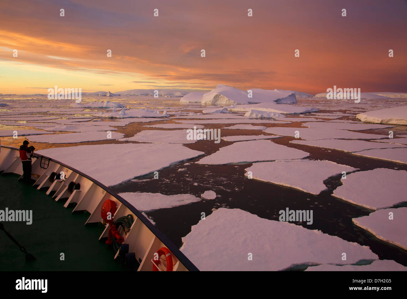 Icebreaker Ortelus muovendo attraverso il ghiaccio al tramonto / sunrise come siamo in viaggio al di sotto del circolo Antartico, l'Antartide. Foto Stock
