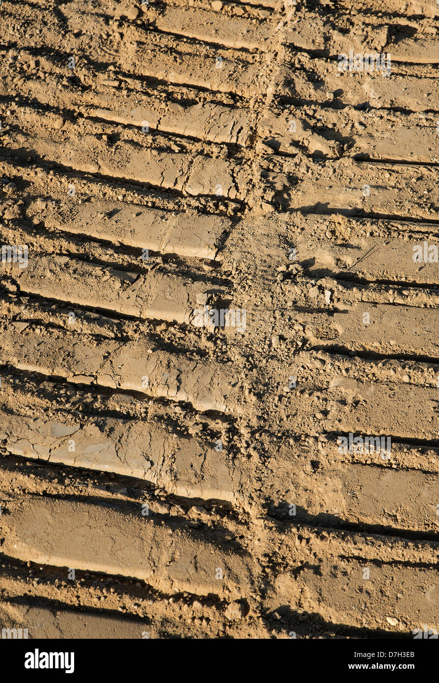 I cingoli del trattore nel terreno ad alloggiamento sito in costruzione. Foto Stock