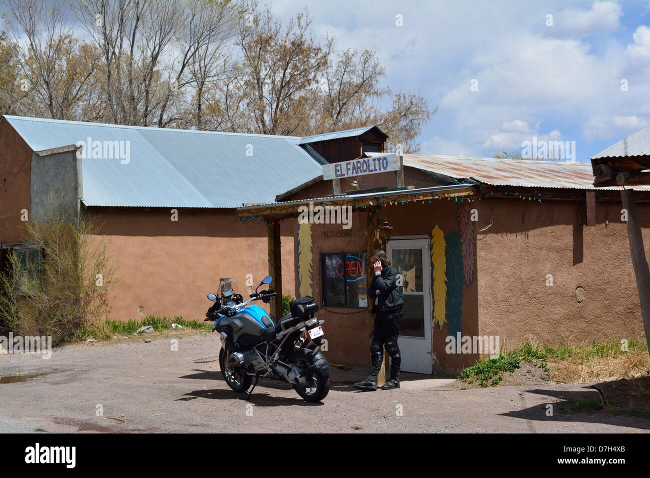Motociclista al di fuori del piccolo villaggio ristorante nel New Mexico settentrionale città di El Rito parlando al cellulare. Foto Stock