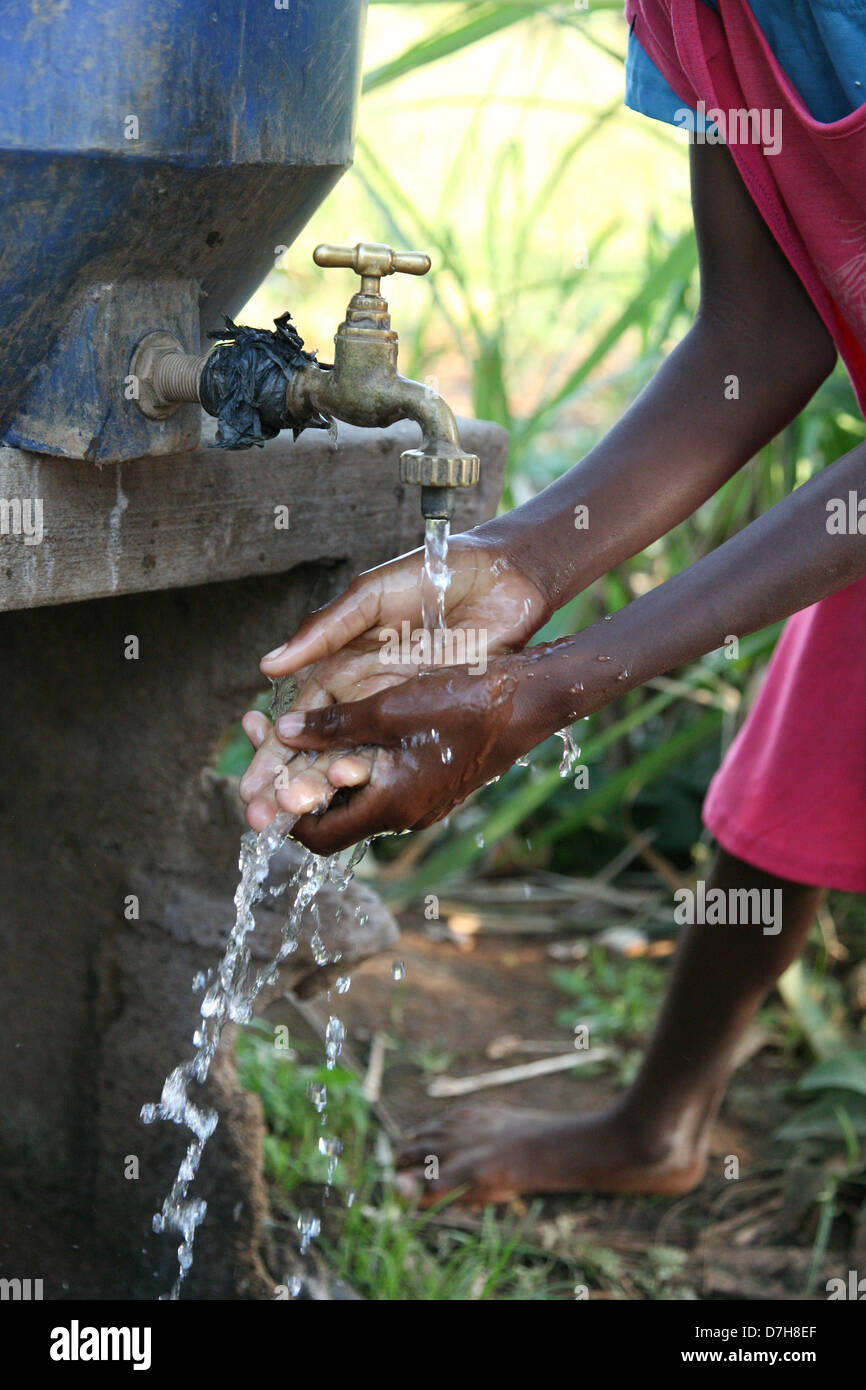 Stretta di mano africani di essere lavati in acqua corrente pulita. Foto Stock