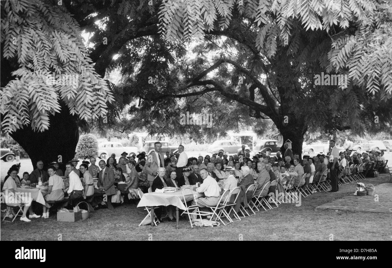 Questa foto degli archivi OSU mostra Clifford Smith in piedi al centro durante un picnic estivo. L'immagine cattura le persone che si divertono all'aria aperta, evidenziando un momento di svago e partecipazione della comunità. Foto Stock