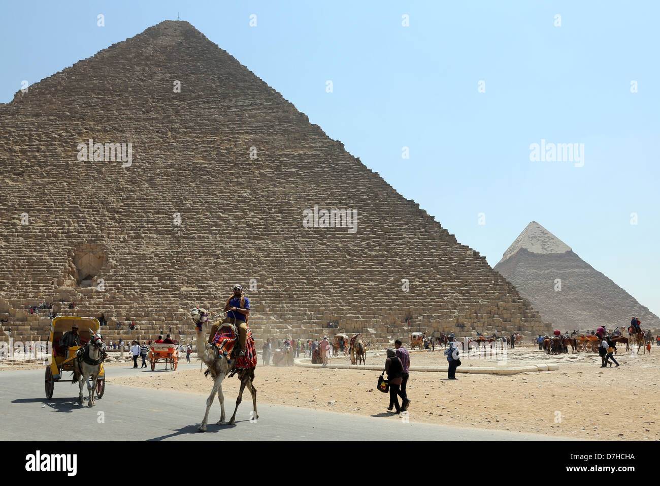 I driver del cammello e turisti davanti alle Piramidi di Giza, Cairo, Egitto Nord Africa Foto Stock