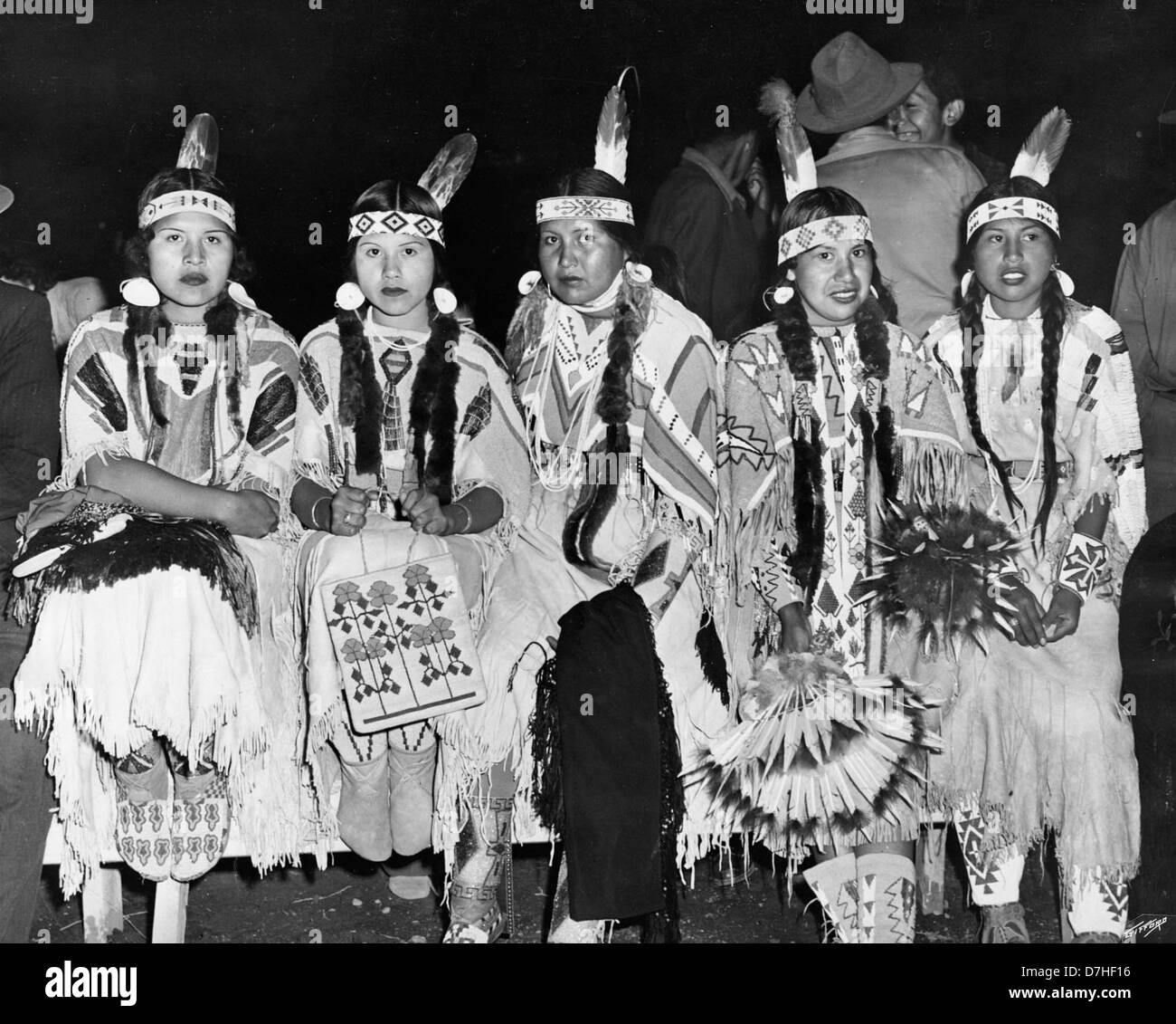 Donne indiane che osservano una danza cerimoniale, catturate in una fotografia dagli archivi dell'OSU. Questa immagine riflette il significato culturale della danza tradizionale nella società indiana, evidenziandone l'importanza nella comunità e nei rituali. Foto Stock
