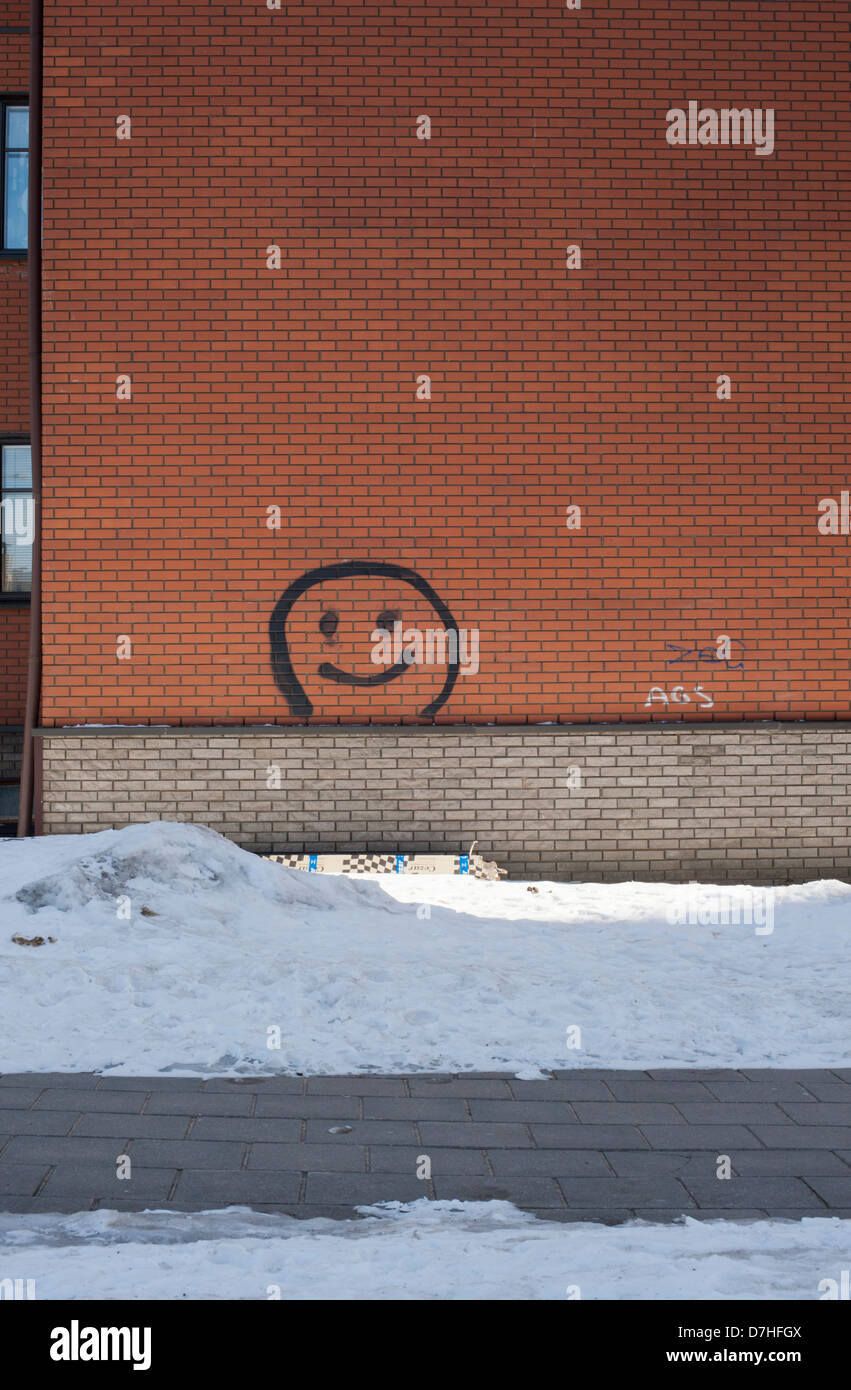 Una faccina sorridente dipinta su un blocco di appartamenti nei sobborghi di coperta di neve di Vilnius. Foto Stock