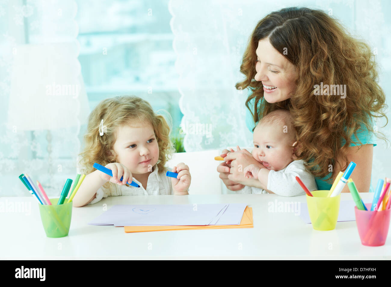Bella madre e il suo disegno per bambini a casa Foto Stock