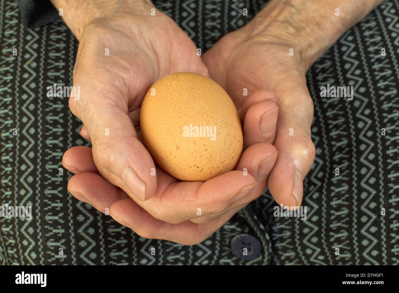 Un uovo in anziani le mani. Foto Stock
