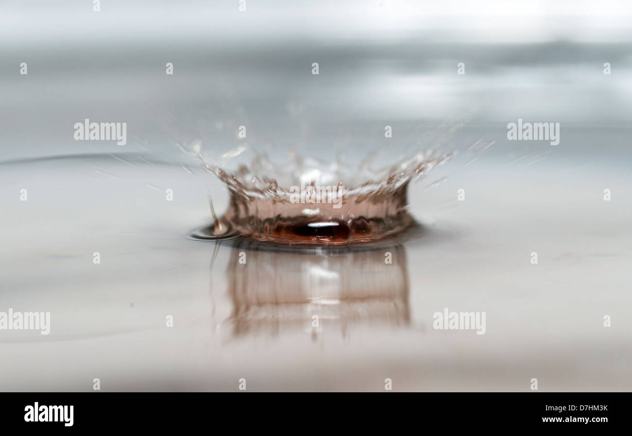 Il movimento di caduta di una goccia di acqua vino rosso in acqua fresca Foto Stock
