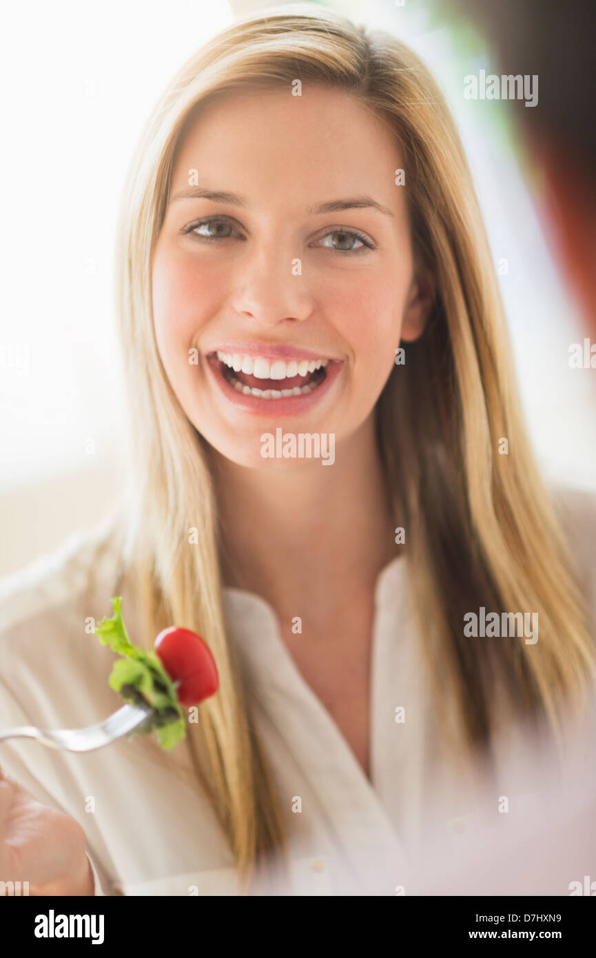 Donna di mangiare e ridere Foto Stock