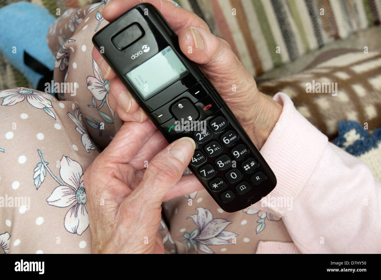 Donna anziana utilizzando un settore specializzato in grande pulsante telefono chiamando il 111 in situazioni di non emergenza consulenza medica helpline a causa di malessere Foto Stock