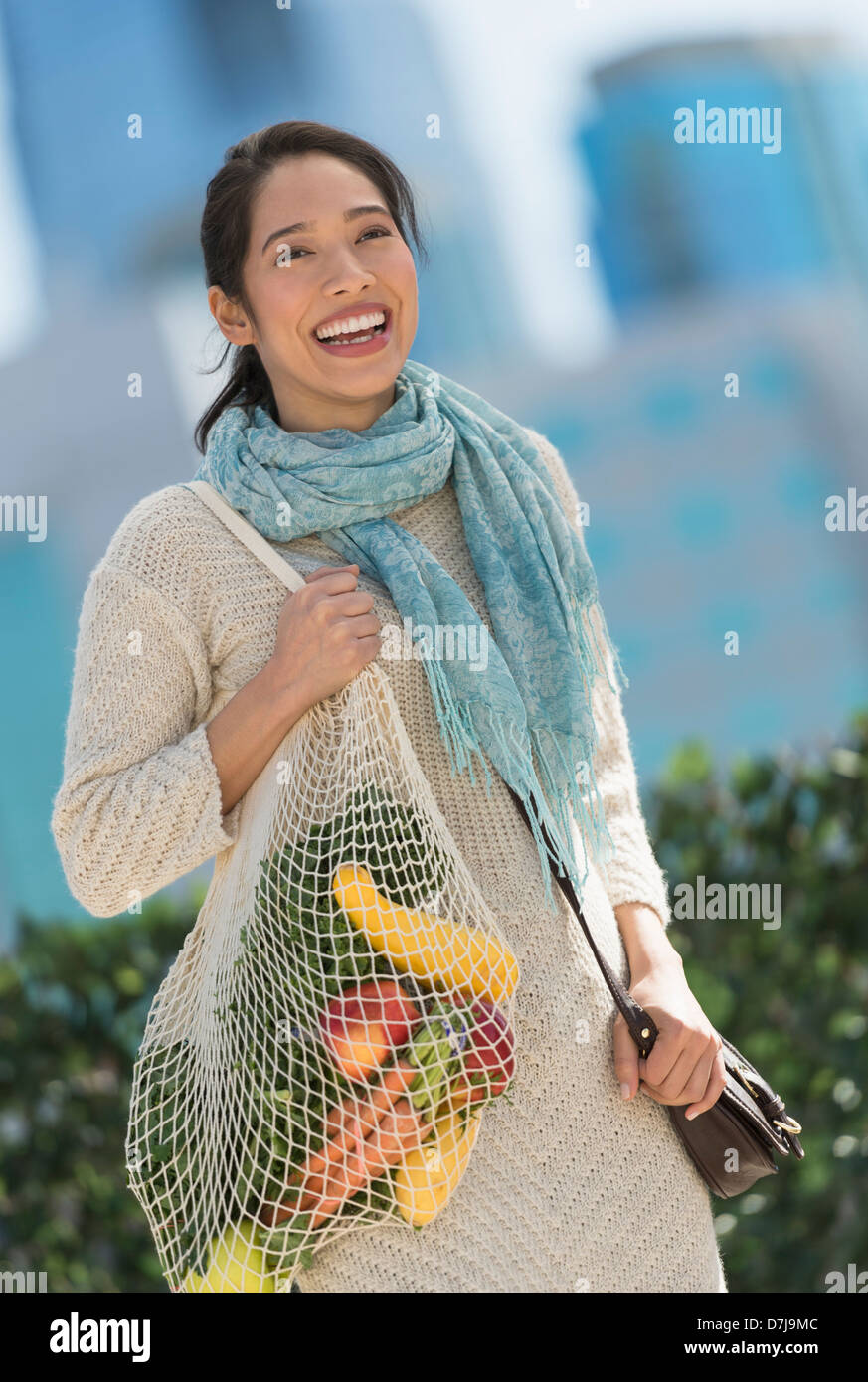 Ritratto di sorridente giovane donna con negozio di generi alimentari shopping bag Foto Stock