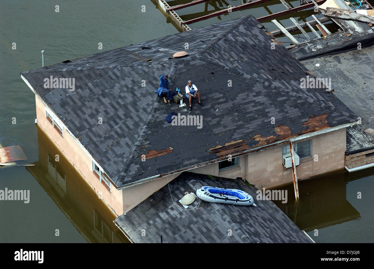 Vista aerea che mostra due residenti bloccati sul tetto da massicce inondazioni e distruzioni causate dall'uragano Katrina Agosto 30, 2005 a New Orleans, LA. Foto Stock