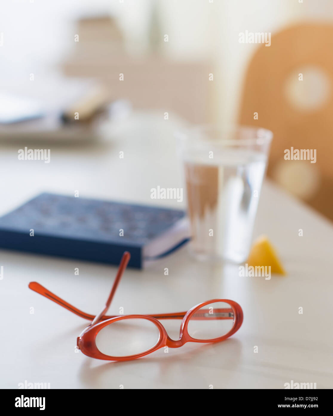 Vista di occhiali, personal organizer e bicchiere di acqua sul tavolo Foto Stock