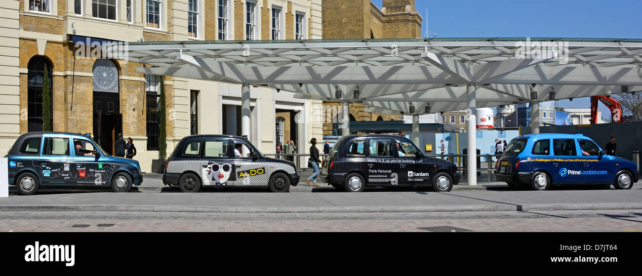 Servizio taxi fuori Kings Cross stazione ferroviaria che mostra la pubblicità sul lato delle cabine Foto Stock