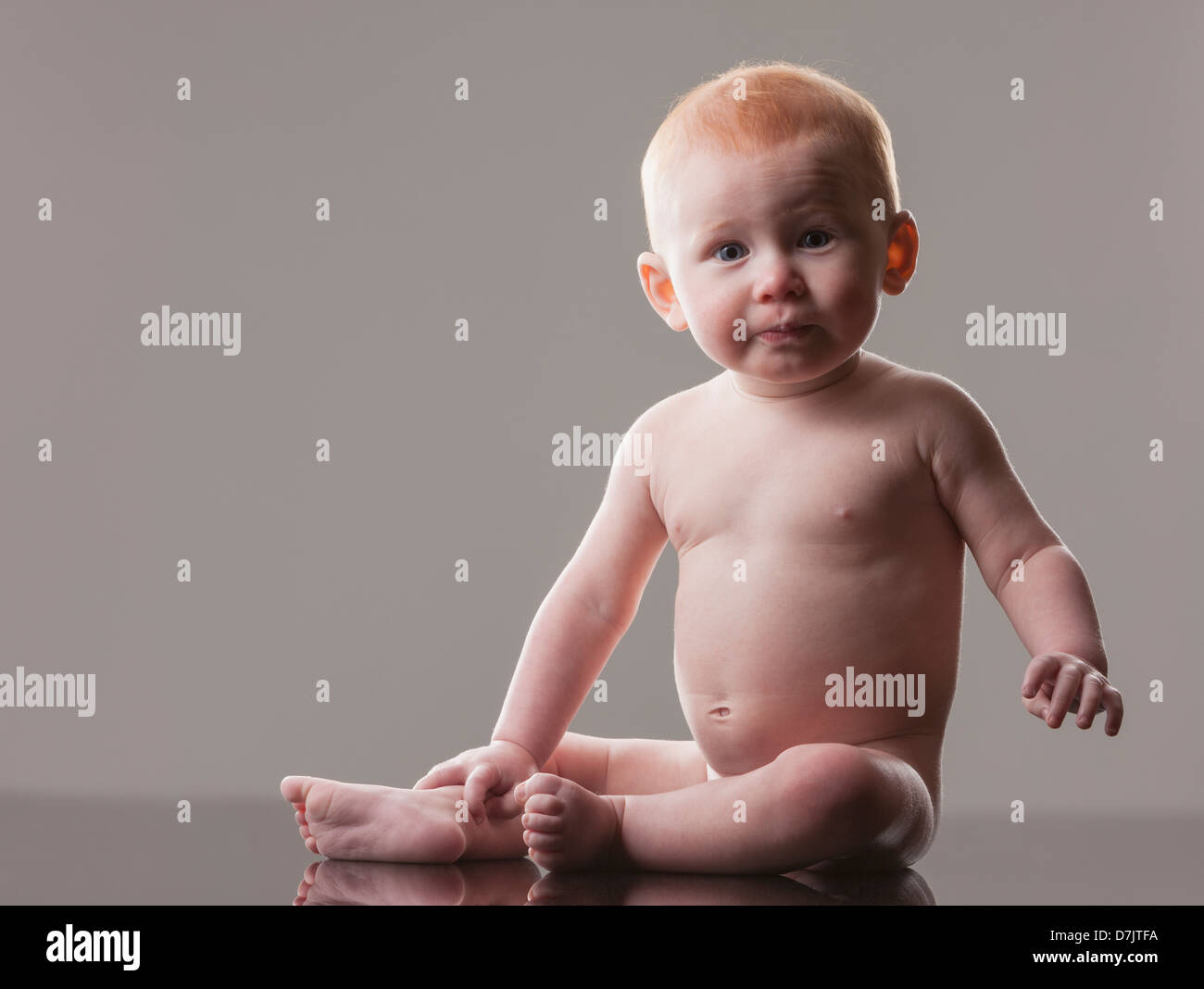Studio shot di nuda baby boy (18-23 mesi) seduta Foto Stock
