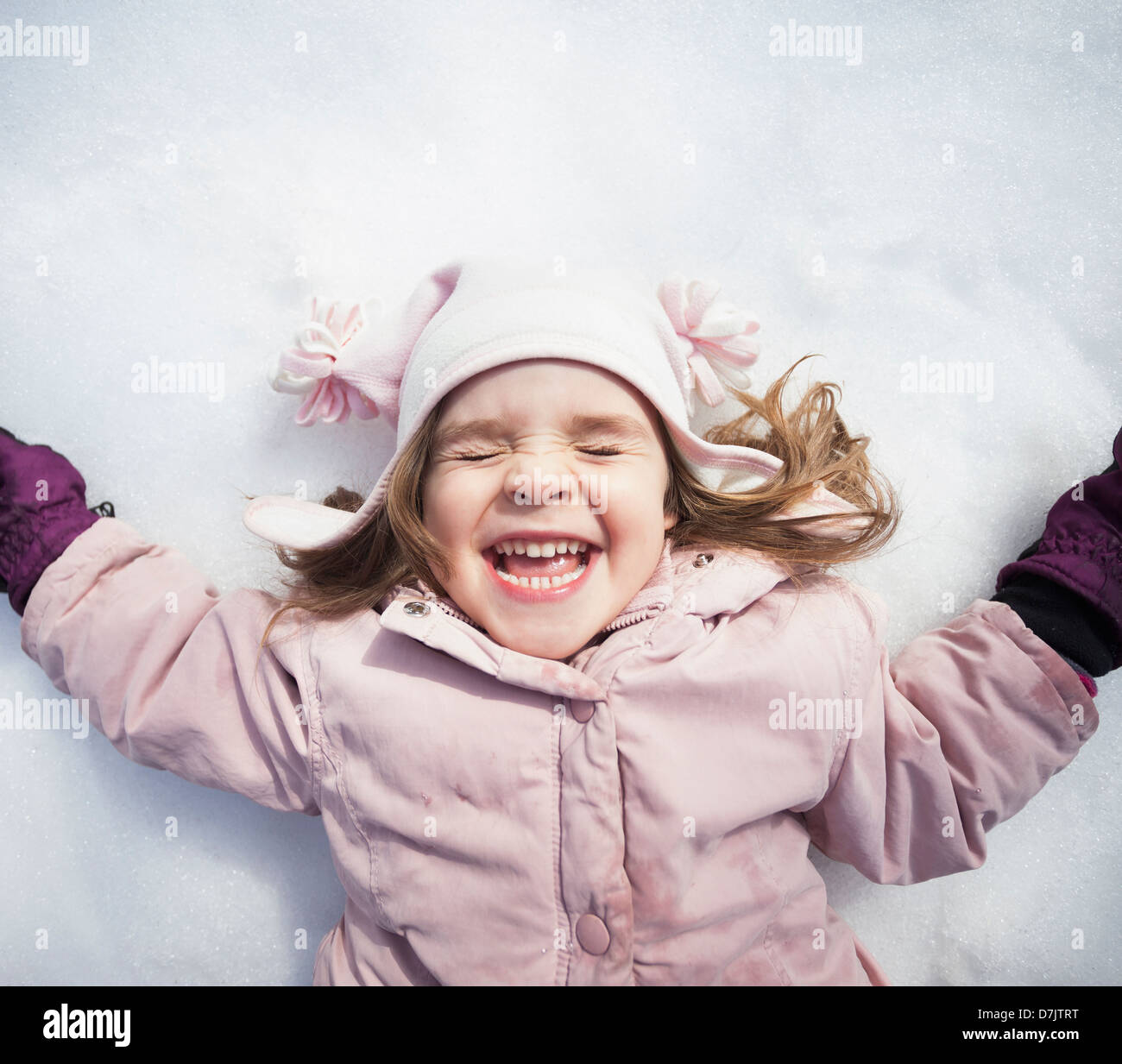 Ritratto di ragazza (2-3) sdraiato sulla neve Foto Stock