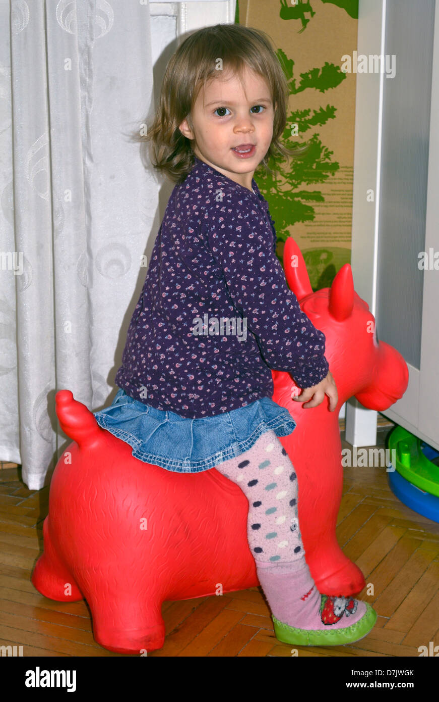 2 anni di bambina di equitazione su pony rosso Foto Stock