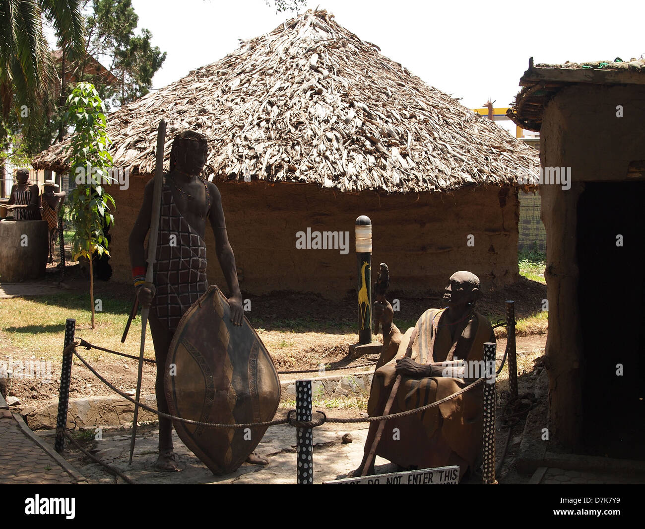 Masai uomini davanti a una capanna nel patrimonio culturale centro di Arusha Foto Stock